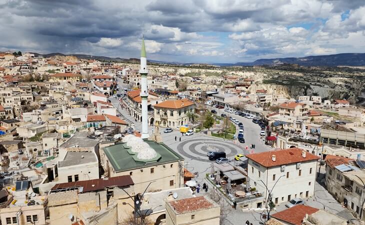 Ortahisar Kalesi’nden kasaba manzarası; cami minaresi, taş evler, meydan ve Kapadokya vadileriyle panoramik Ortahisar görünümü